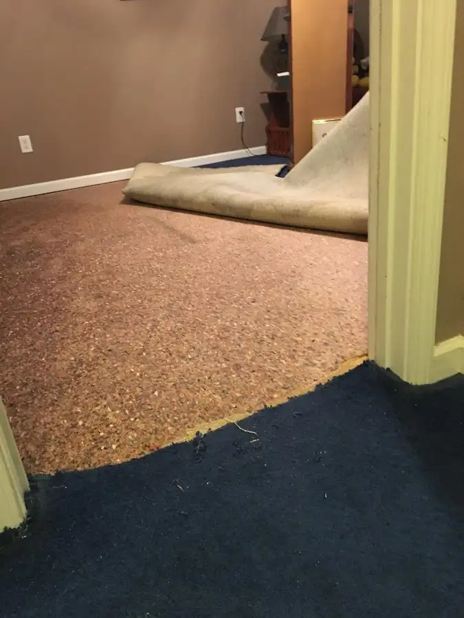 Carpet pad removal revealing water damage during Water Mitigation Services in Streetsboro